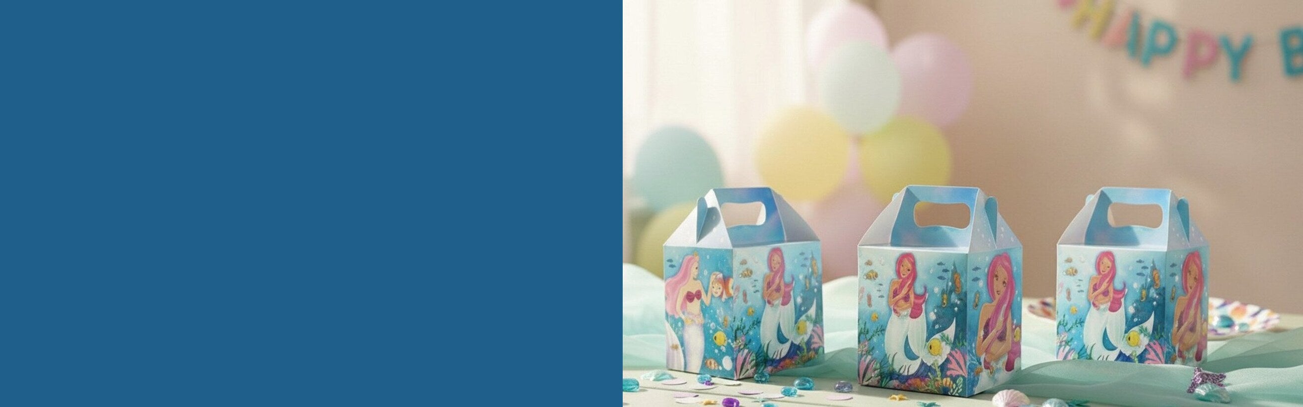 Three Magical Mermaids party boxes on a pastel table with confetti and balloons